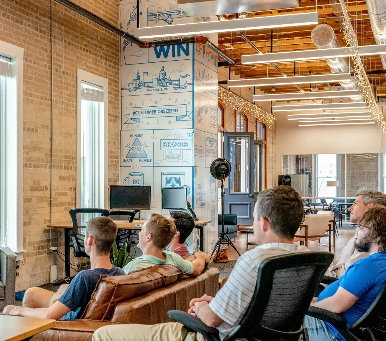 Small office seminar with seated coworkers who are engaged